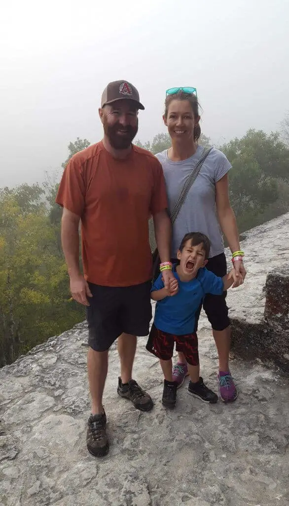 Tikal Sunrise Tour- Chad, Diane, and Eli standing on Jaguar Temple with fog in the background