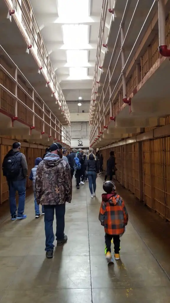 Eli and Chad walking through the halls of Alcatraz listing to the adio tour - 2 day San Francisco Itinerary