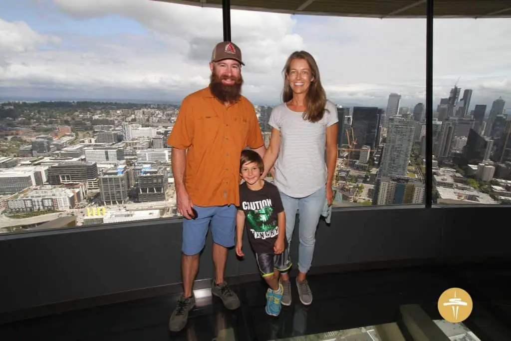 Family in the space needle with Seattle in the background