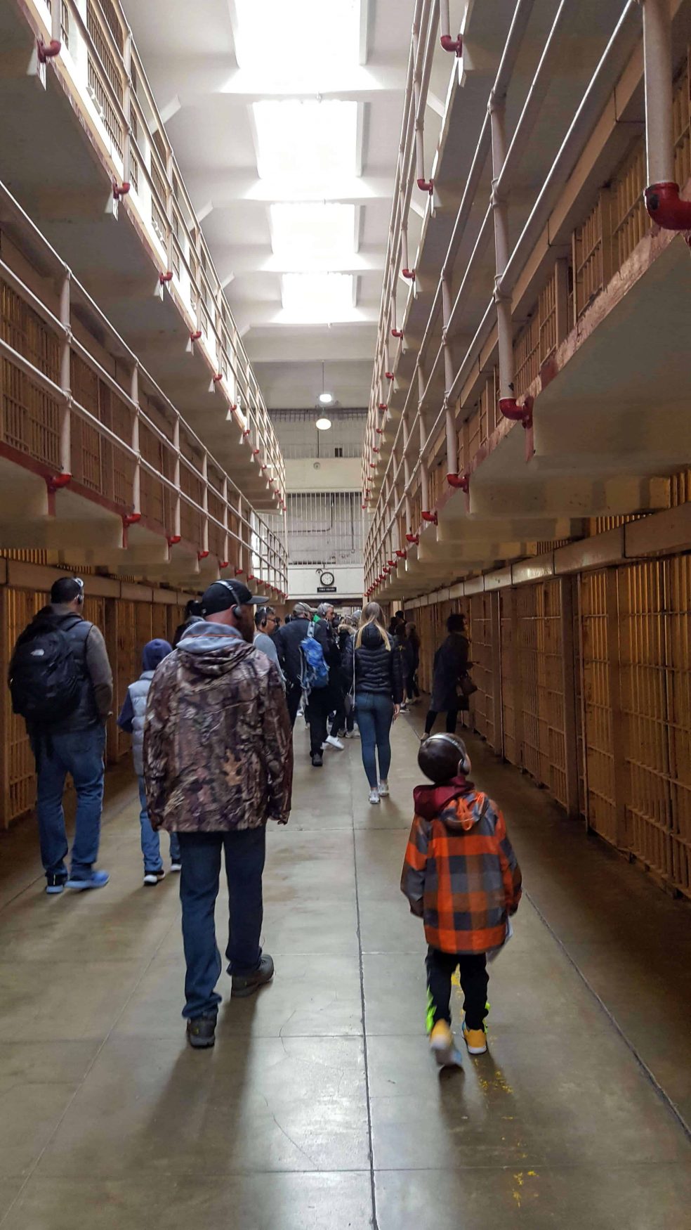 Eli and Chad walking through the halls of Alcatraz listing to the adio tour
