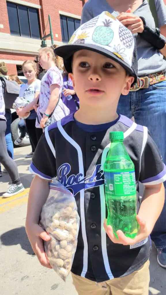 Eli standing outside coors field with a sprite and peanuts