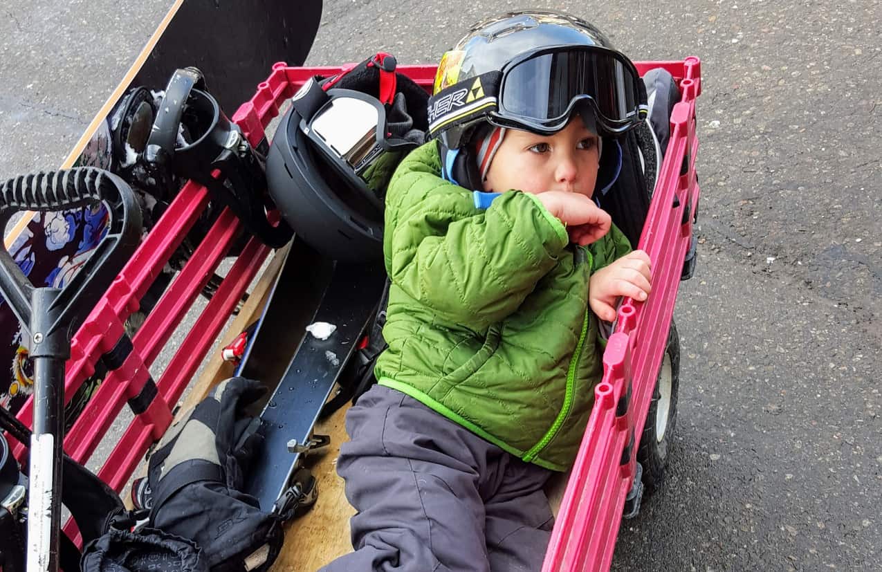 Eli in a red wagon with his ski gear at Keystone Ski Resort