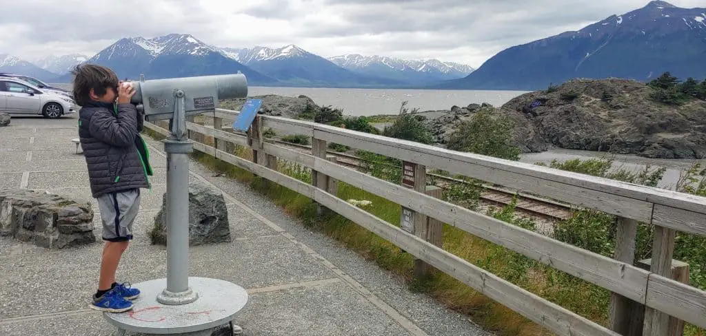 boy looking out over Beluga Point at the mountains and ocean between Anchorage and Girdwood