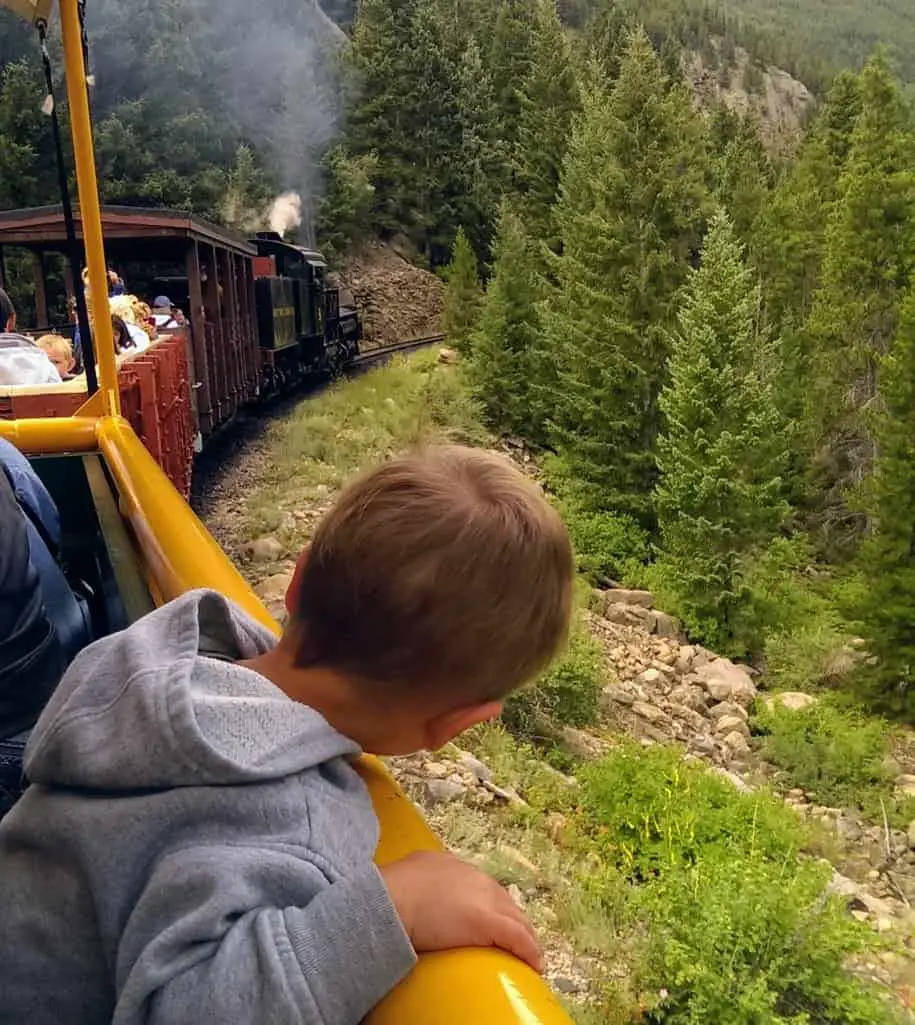 boy looking over the railing of the Georgetown Loop Train
