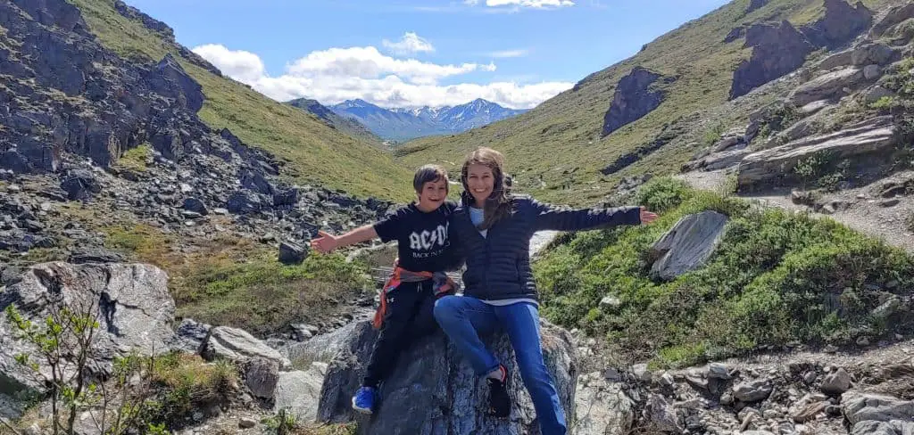 mom and son sitting on a rock on the savage river trail in Denali National Park