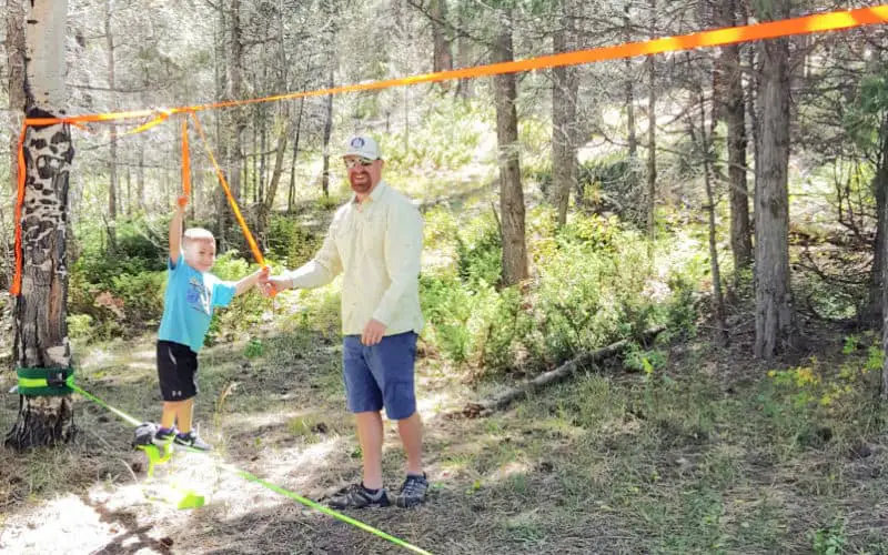 father and son playing on a slackline - camping essentials with kids