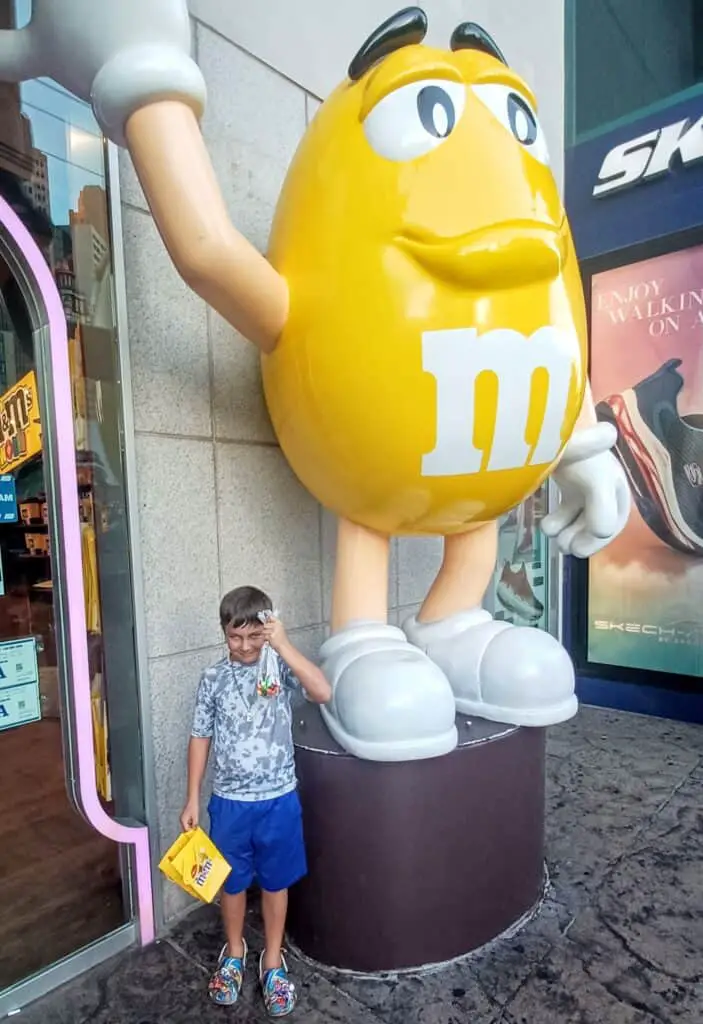 Child in front of a big yellow M&M - fun thing to do in Las Vegas with kids