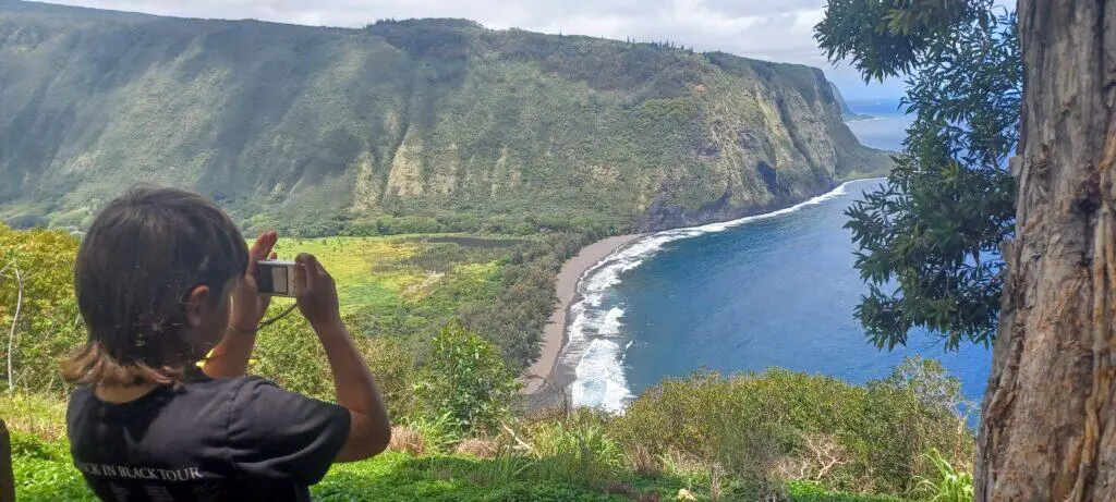 Boy taking a picture of Waipio Valley on the Big Island of Hawaii