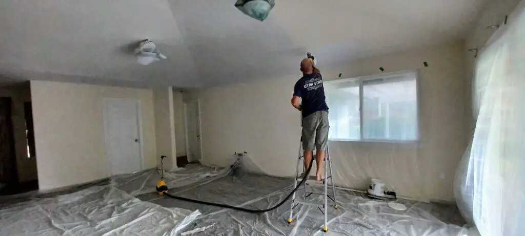 man painting the inside walls of a house