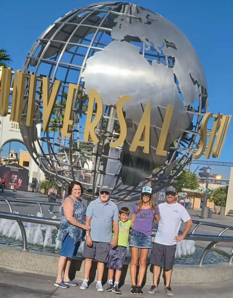 family standing in front of the Universal Studios sign in Hollywood, CA