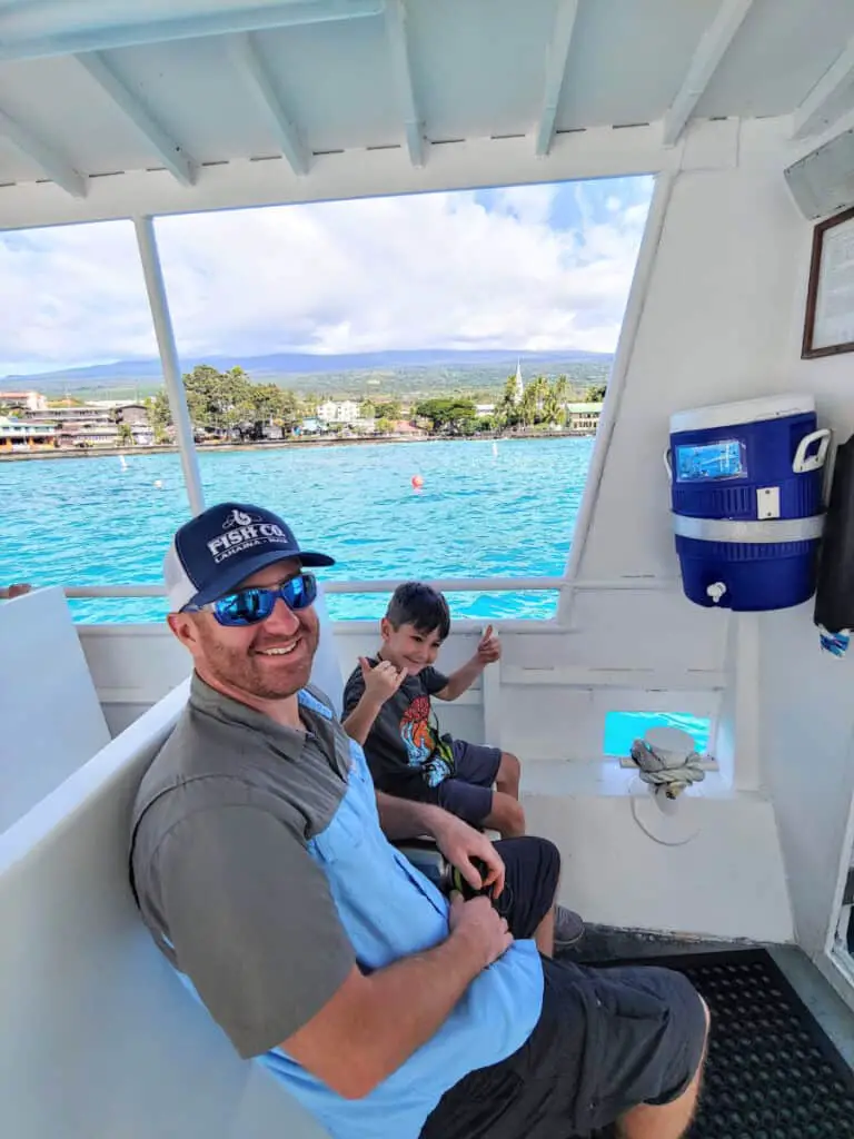 father and son on the shuttle boat to the Kona Atlantis submarine with Kona in the background