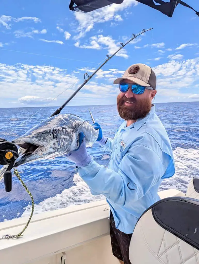 Man holding a fish he caught on his boat in Hawaii